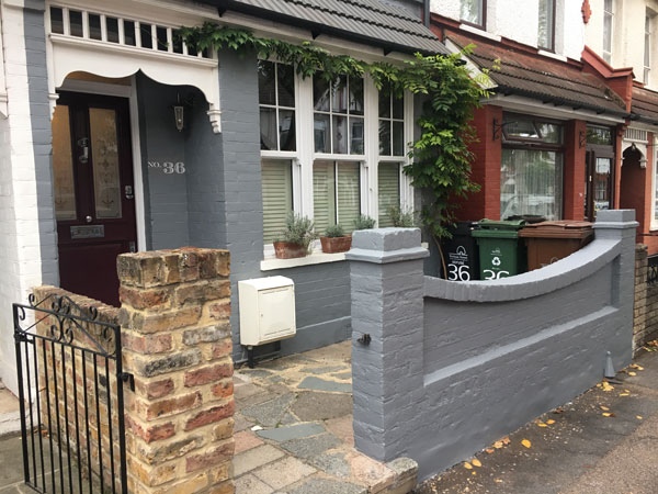 Grey painted wall and brinjal front door